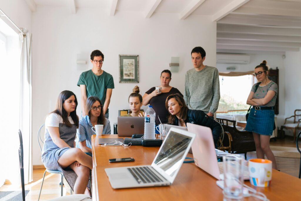 pexels-photo-1595385-1595385 Group of young professionals engaged in a collaborative meeting in a modern office setting.